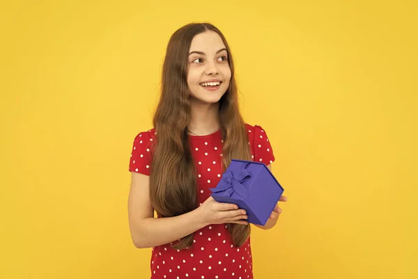 若い10代の女の子の子供は黄色の背景に隔離されたギフトボックスを保持する 子供の誕生日プレゼント — ストック写真