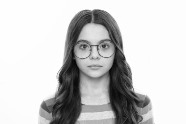 Sarı arka planda izole edilmiş sevimli, zeki küçük kız portresi. Ciddi bir beyaz çocuk kameraya bakıyor.