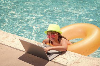 Yaz işi. Çocuk uzaktan kumandası bilardoda çalışıyor. Küçük iş adamı yazın havuz suyunda dizüstü bilgisayarda çalışıyor. Tropikal plajda çalışan küçük iş adamı