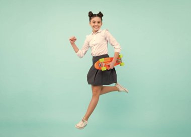 Teen hipster girl skater with skateboard on isolated background. Jump and run. Summer kids trend, urban teenage style