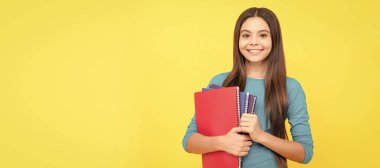 Neşeli kız çocuğu ödev ve ödev için not defteri tutuyor. Öğrenci pankartı. Kopya alanı olan öğrenci portresi