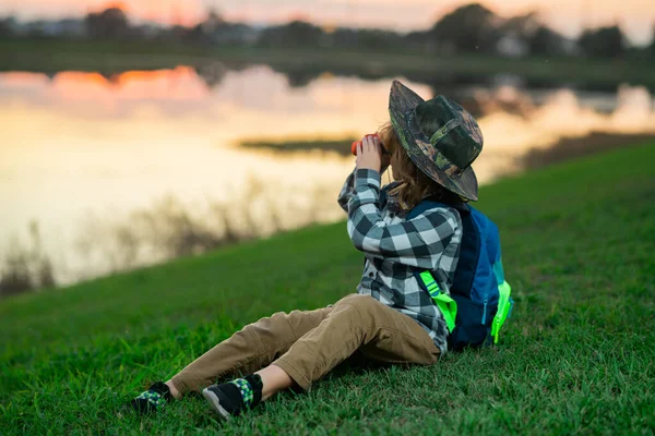 快乐的孩子玩双筒望远镜 探险和冒险 带背包的小男孩探索自然和环境 儿童户外休闲活动 游客的夏季旅行 免版税图库照片