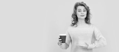 İzole edilmiş yüz portresi, fotokopi alanı olan pankart. Mutlu kızıl saçlı kadın kahve bardağının içinde kahve içmenin ürününü sunuyor.