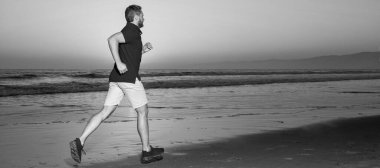 Man running and jumping, banner with copy space. sportsman sprinter running on sunrise summer beach at ocean, challenge