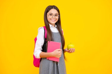 Okul çocukları konsepti. Okula dönelim. Okul çocuğu, çantasında elma ve kitap olan genç kız.