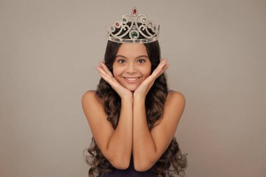 Girls party, funny kid in crown. Child queen wear diadem tiara. Cute little princess portrait. Happy girl face, positive and smiling emotions