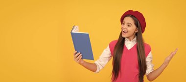 Konuşmacı. Gülümseyen çocuk kitabı okuyor. Genç bir öğrenci. Öğrenci portresi, stüdyo afişi. Okul çocuğu yüzü, boşluklar