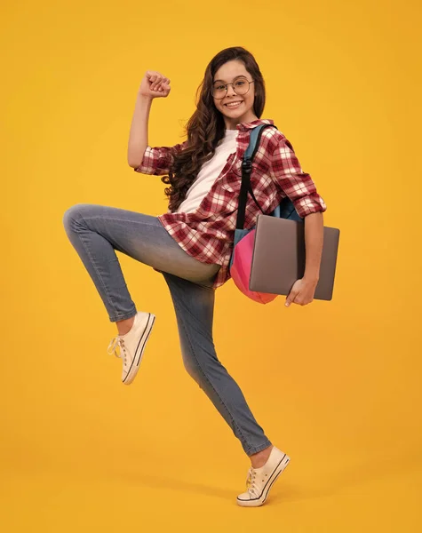 stock image Young girl student, studying hold computer. E-learning concept. Funny pupil with laptop. Back to school. Run and jump, jumping kid