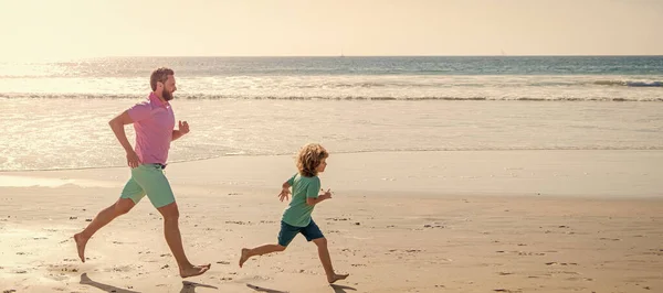 Father and son run on summer beach outdoor, banner poster with copy space, happy dad and child have fun outdoors. father and son running on summer beach
