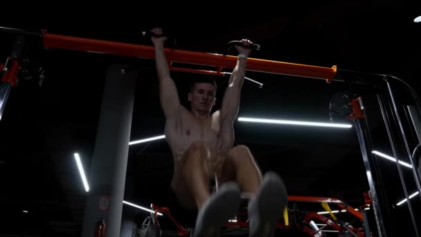 スポーティな男のトレーニング Abs 足を吊るして6パックの練習 ジムで筋肉トルソとシャツのないスポーツマン 筋肉のスポーツマンは トレーニングを休む 6パックトルソ筋のための運動 — ストック動画
