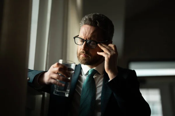 Tired, headache and eye strain from laptop. Businessman with stress, burnout and fatigue eyestrain. Business man rubbing tired eyes after computer work