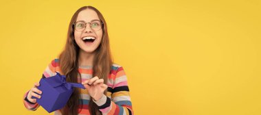 Gözlüklü mutlu genç kız doğum günü hediyesi kutusunu açıyor. Doğum günü hediyeli genç kız, yatay poster