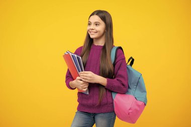 Liseli kız, genç kız, sarı izole stüdyo geçmişi üzerine kitap tutuyor. Okul ve eğitim kavramı. Okula geri dön.