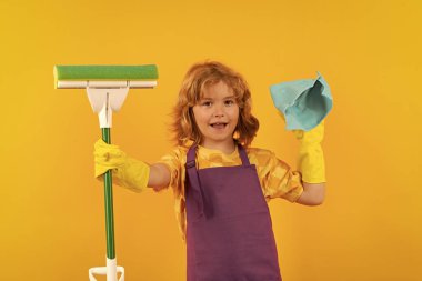 Çocuk ev işi yapıyor. Çocuk portresi temizleme için toz bezi ve eldiven kullanın. Komik çocuk paspas evi. Aksesuar temizleme, temizlik malzemeleri. Oda servisi ve ev temizliği.