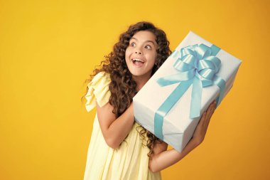 Teenager kid with present box. Teen girl giving birthday gift. Present, greeting and gifting concept. Excited teenager, glad amazed and overjoyed emotions