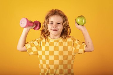 Dambıl kaldıran bir çocuk. Dambılı şirin çocuk eğitimi. Çocuk fitness. Çocuk, dambıllarla egzersiz yapıyor. Sağlıklı çocuklar