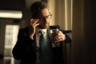 Yorgun adamın korkunç bir baş ağrısı var. Bitkin, sağlıksız hisseden, baş ağrısı hastalığına üzülen bir adam. Stresli orta yaşlı adamın başı ağrıyor. Migren ve baş ağrısı konsepti