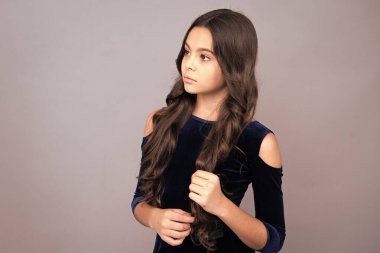 Gri arka planda çocuk stüdyo resmi. Çocukluk yaşam tarzı konsepti. Sevimli genç kız yüzü. Yakından.