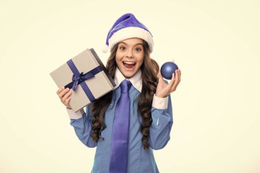 Noel Baba 'nın kızı. Yeni yıl ya da Noel hediyesi. Heyecanlı bir yüz. Stüdyonun arka planında hediye kutusu olan çocuk. Çocukların doğum günü hediyesi. Şaşırtıcı bir ifade, neşeli ve mutlu.