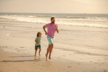 fathers or family day. daddy with kid boy on summer day. dad and child having fun outdoors. childhood and parenting. father and son running on sea beach. family travel weekend and vacation.