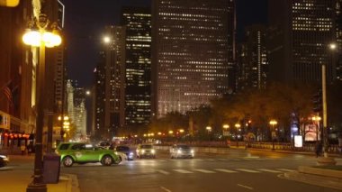 Chicago, ABD - 16 Mayıs 2023: Yol trafiği ve gökdelenli Chicago şehrinin gece manzarası, yavaş çekim.
