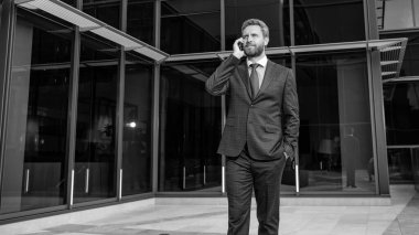 İş adamı kılığındaki güler yüzlü girişimci ofis dışında telefon görüşmesi yapar, iş görüşmesi yapar..