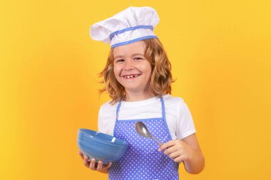 Aşçıbaşı aşçı çocuk. Aşçı çocuk. Çocuk fırın üniforması ve aşçı şapkası giyiyor yemek hazırlıyor, stüdyo fotoğrafı çekiyor.