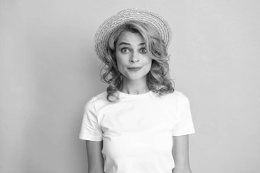 Hasır şapkalı genç kızıl saçlı kadın, şaşırmış yüz ifadesi, sarı arka planda soyutlanmış. Yaz yaşam tarzı stüdyo resmi