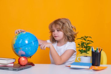 Zeki, beyaz, liseli bir öğrenci okula geri dönüyor. Eğitimli çocuklar. Okullu çocuk sarı arka planda izole edilmiş.