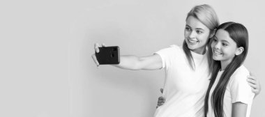 Anne ve kız çocuk afişi, kopyalama alanı, izole bir arka plan. Online iletişim. Anne ve çocuk blogu. Güzel kadın ve kız selfie çekiyorlar.