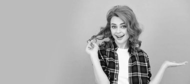 happy redhead woman with curly hair in checkered casual shirt presenting product, Woman isolated face portrait, banner with mock up copyspace
