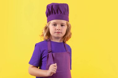 Aşçı çocuk. Çocuk fırın üniforması ve aşçı şapkası giyiyor yemek hazırlıyor, stüdyo fotoğrafı çekiyor.