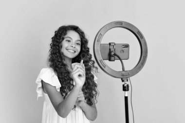 Çocuk video kaydedicisi telefonda video blogu yapıyor. Web günlüğü ve vlog. Genç kız blogger etkileyicisi sosyal medya için video kaydediyor. Mutlu ergen, pozitif ve gülümseyen genç kız duyguları