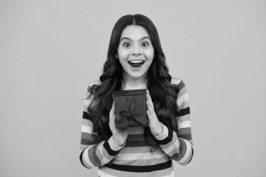 Amazed teenager. Portrait of teenager child girl 12, 13, 14, years old holding Christmas gift box. Teen giving birthday gift. Excited teen girl