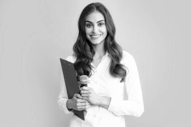 Smiling young woman as reporter with microphone and clipboard. Female journalist with microphone and clipboard