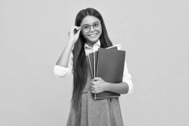 Genç kız öğrenci kitapları, not defterleri, sarı arka planda izole edilmiş, kopyalama alanı. Okula dönüş, gençlik yaşam tarzı, eğitim ve bilgi. Mutlu kız yüzü, pozitif ve gülümseyen duygular