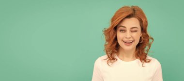 Mavi arka planda kıvırcık saçlı kızıl saçlı kadın. İzole edilmiş yüz portresi, kopyalama alanı olan pankart