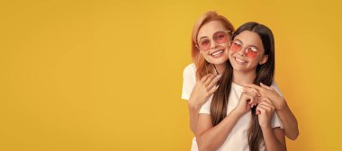 Anne ve kız çocuk afişi, kopyalama alanı, izole edilmiş arka plan. Genç anne ve çocuğun mutlu aile portresi. Gözlüklü, yaz modasında.