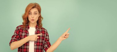 Mavi arka planda kareli gömlekli, kızıl saçlı, komik bir kadın. İzole edilmiş yüz portresi, kopyalama alanı oluşturulmuş pankart