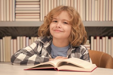 Okula dönelim. Kütüphanedeki çocuk kitap okur. Okul kütüphanesinde kitap seçen bir öğrenci. Çocuk edebiyatı. Kitapçıdaki çocuk. Kitaplardan öğreniyorum. Okul eğitimi