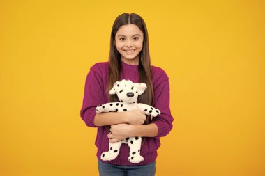 Teenage girl embracing toy. Childhood, toys and kids. Cute teen girl cuddling favorite fluffy toy