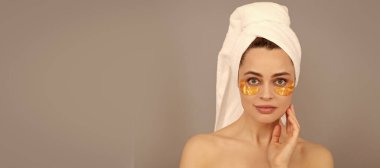 Göz bandı. Terry Havlu 'lu şehvetli kadın cilt ve kaplıca için altın göz bandı kullanıyor. Güzel kadın, izole edilmiş yüz portresi, taklit alanı olan pankart.