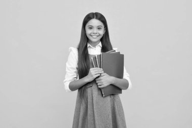 Genç kız öğrenci kitapları, not defterleri, sarı arka planda izole edilmiş, kopyalama alanı. Okula dönüş, gençlik yaşam tarzı, eğitim ve bilgi. Mutlu kız yüzü, pozitif ve gülümseyen duygular