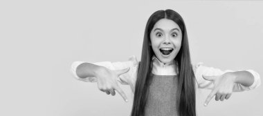 happy teen girl point finger on blank pink paper sheet for copy space, promotion. Child face, horizontal poster, teenager girl isolated portrait, banner with copy space