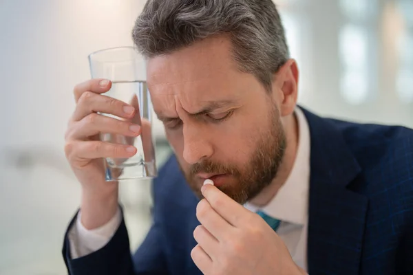 stock image Sad man with laptop got migraine touches her head because of pain. Man manager with strong headache. Man taking a Medicine pill from headache migraine