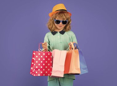 Little buyer customer. Child on shopping. Portrait of child boy with shopping bags. Fashion child in shirt, sunglasses and hat