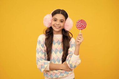 Teenage girl with candy lollipop, happy child 12, 13, 14 years old eating big sugar lollipop, sweets candy