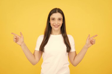 Kadın fotokopi alanını işaret ediyor, kopyalama alanını gösteriyor. Promosyon, reklam içerikli jest gösteren kız, elle tavsiye edilen ürünü işaret ediyor. İzole edilmiş arkaplan