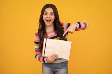 Amazed teenager. Teenage school girl with books. Schoolgirl student. Excited teen girl