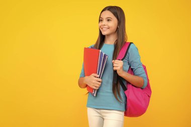 Happy teenager portrait. School teenager child girl 12, 13, 14 years old with book and copybook. Teenager schoolgirl on isolated background. Learning and knowledge education concept. Smiling girl